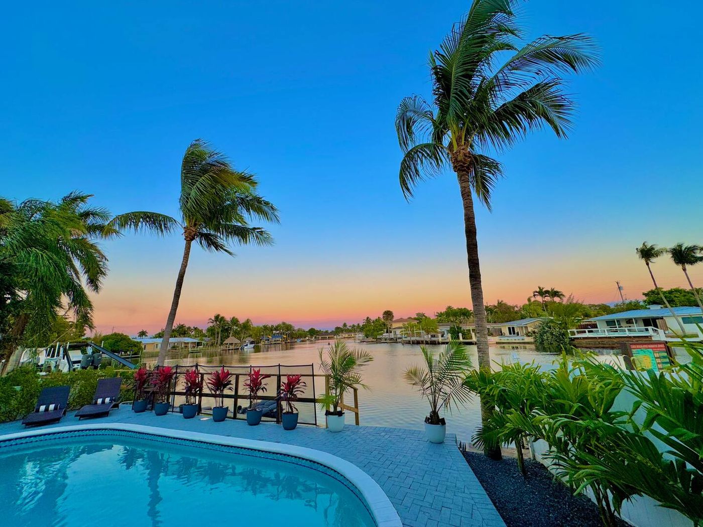 Pool and canal at sunset with palms